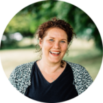 Jo Burrill, smiling, outdoors with green park background