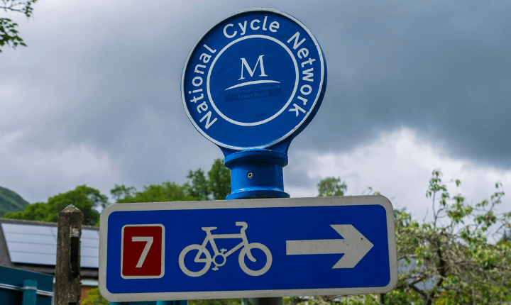 Blue National Cycle Network sign in the green outdoors