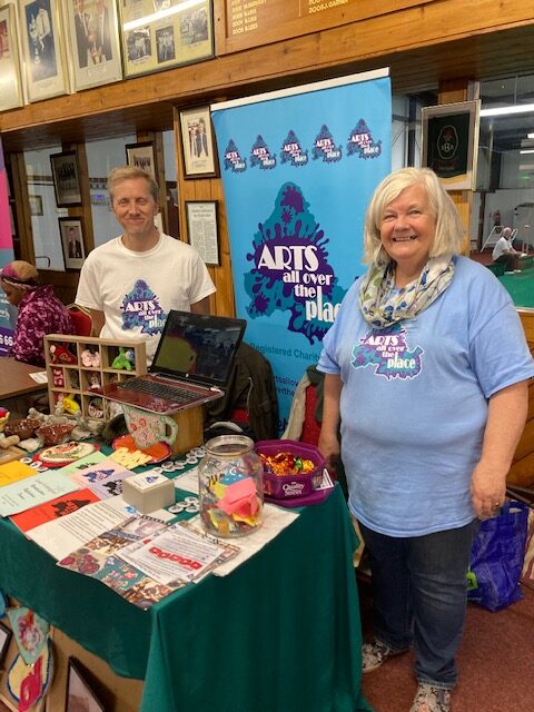 Trevor and Cathy from AAOTP at a networking event, with AAOTP banner and materials