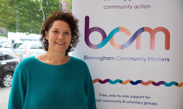 Jo Burrill standing next to BCM pull-up banner