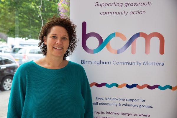 Jo Burrill standing next to BCM pull-up banner