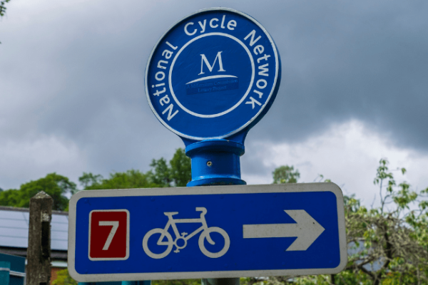 Blue National Cycle Network sign in the green outdoors